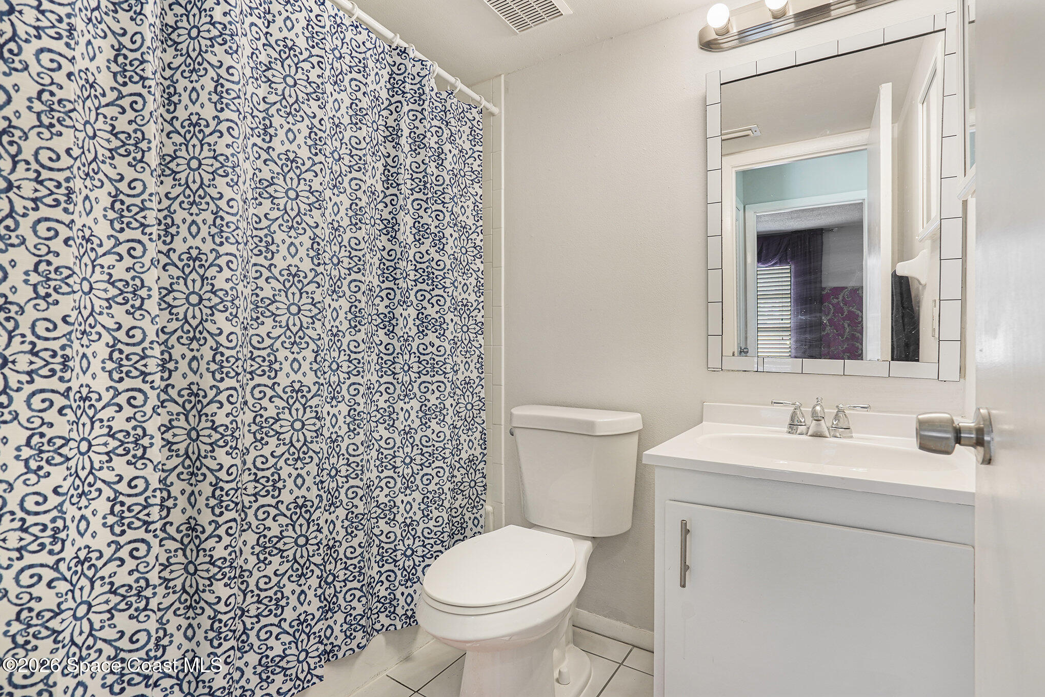 1225 North Wickham Road, Unit 411 Melbourne, FL 32935 - Photo 15 of 26 a bathroom with a toilet sink and mirror