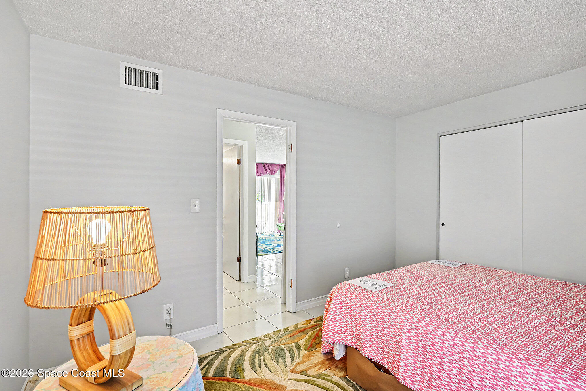 1225 North Wickham Road, Unit 411 Melbourne, FL 32935 - Photo 18 of 26 a bedroom with a bed and wooden floor