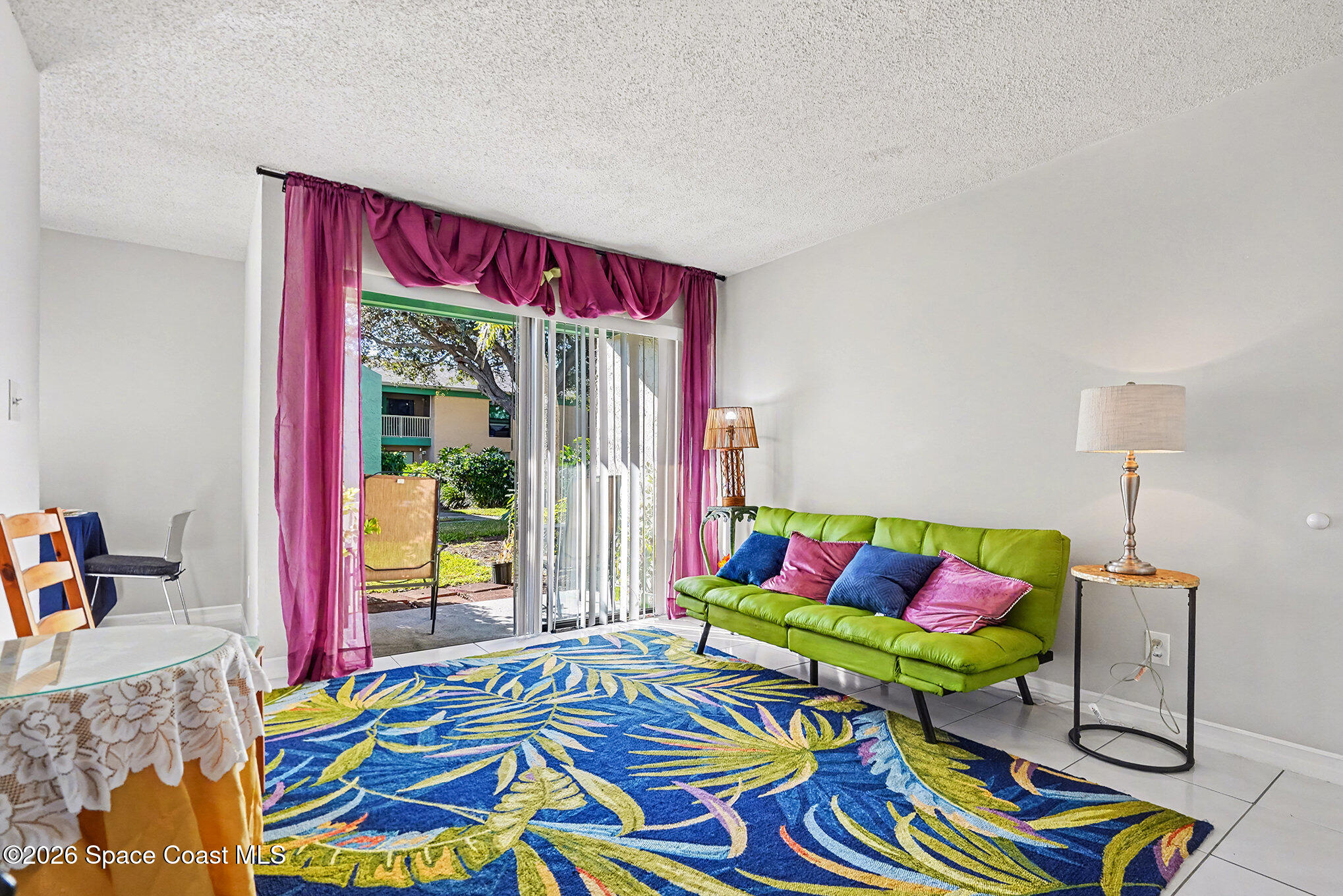 1225 North Wickham Road, Unit 411 Melbourne, FL 32935 - Photo 6 of 26 a living room with a bed and a table