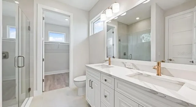 a kitchen with stainless steel appliances granite countertop a stove a refrigerator a kitchen island a table and chairs