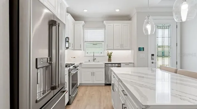 a kitchen with white cabinets and white appliances