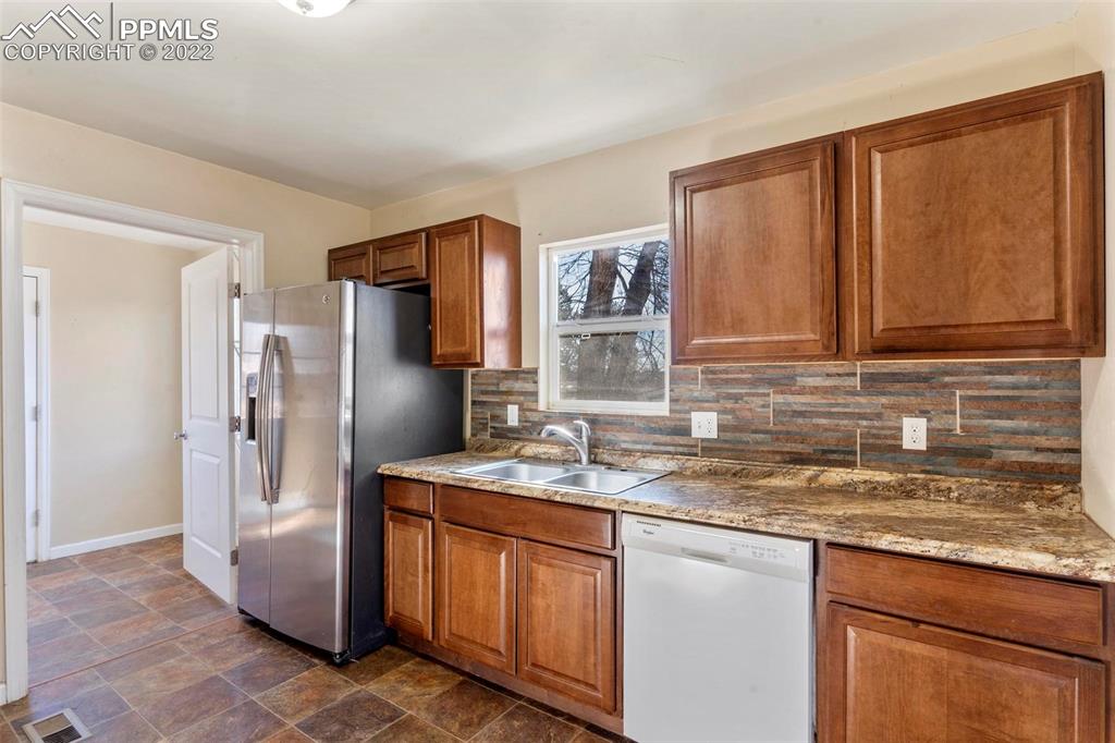 921 Alexander Road Colorado Springs, CO 80909 - Photo 3 of 10 a kitchen with stainless steel appliances granite countertop a refrigerator and a sink