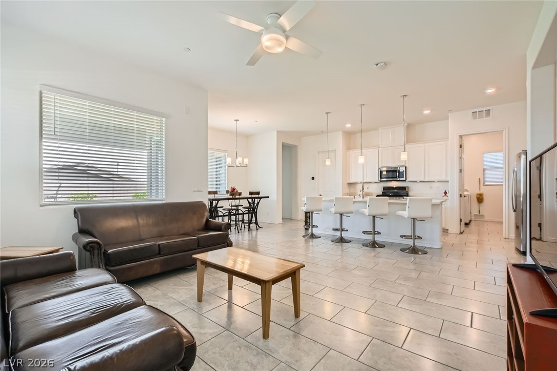 498 Pebble Run Avenue Henderson, NV 89011 - Photo 4 of 47 A spacious and inviting living area transitions seamlessly into a well-appointed kitchen, perfect for entertaining.