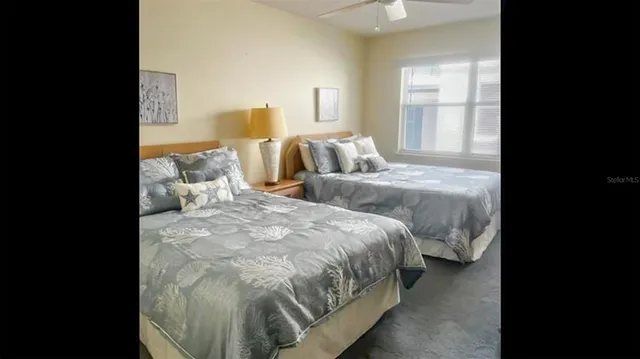 a spacious bedroom with two beds and a window