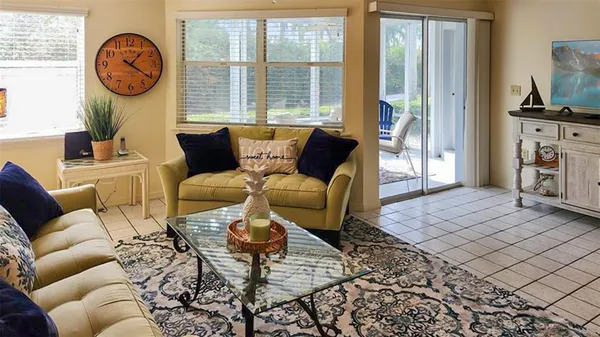 a living room with furniture a fireplace a rug and a large window