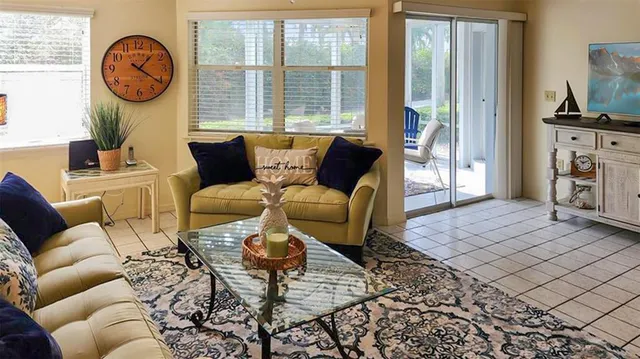 a living room with furniture a fireplace a rug and a large window