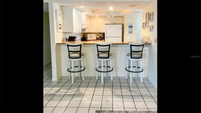 a dining room with stainless steel appliances a dining table chairs and fireplace