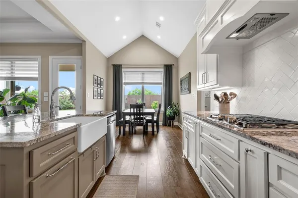 a kitchen with stainless steel appliances a stove a sink dishwasher and cabinets with wooden floor