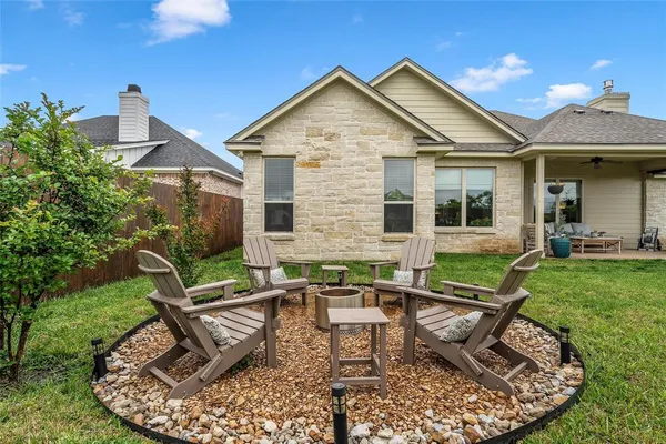 a view of a house with backyard sitting area and garden