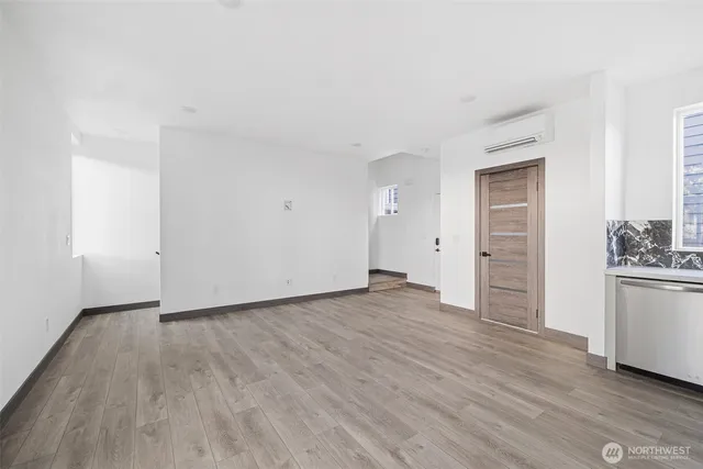 an empty room with wooden floor and cabinet