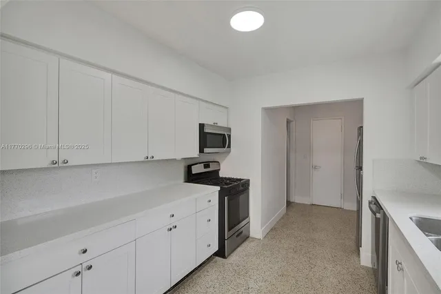 a kitchen with cabinets stainless steel appliances and sink