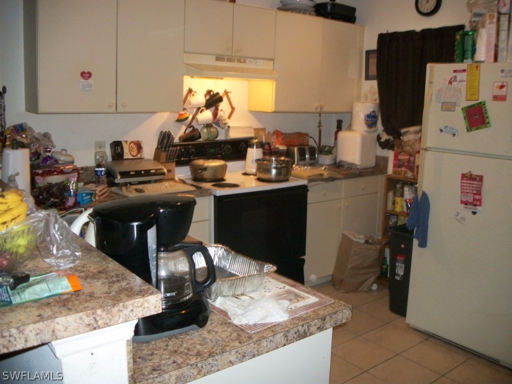 801 Meadow Road Lehigh Acres, FL 33973 - Photo 3 of 13 a room with kitchen island granite countertop a sink appliances and cabinets