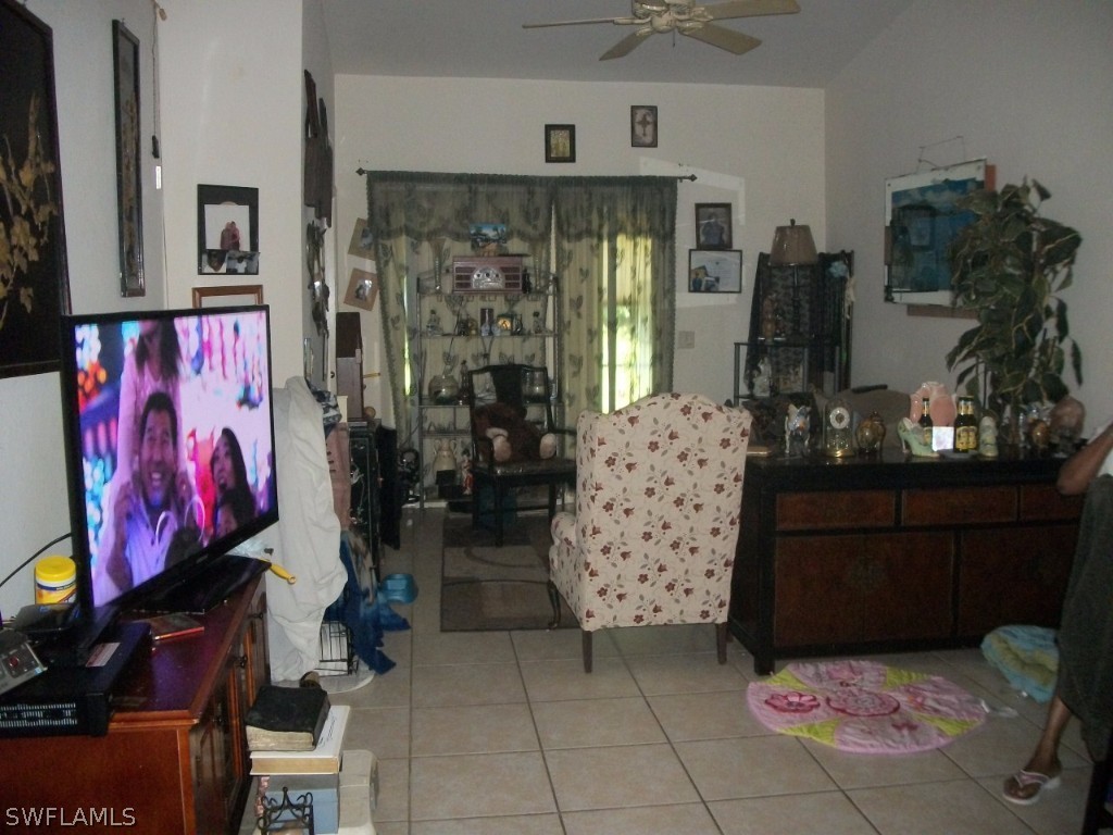 801 Meadow Road Lehigh Acres, FL 33973 - Photo 7 of 13 a view of entryway with a room that has a rug and a chandelier