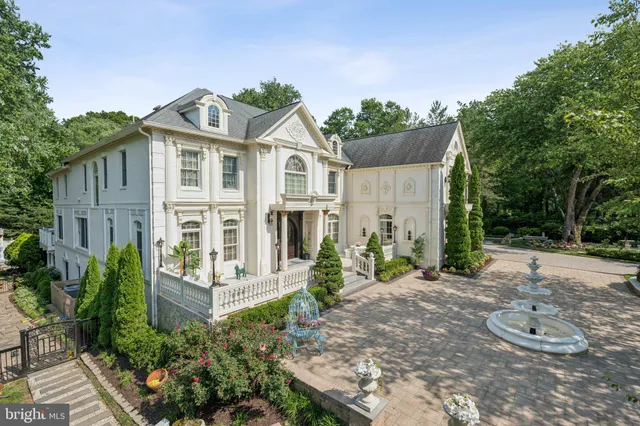 a view of a white house with large windows and plants