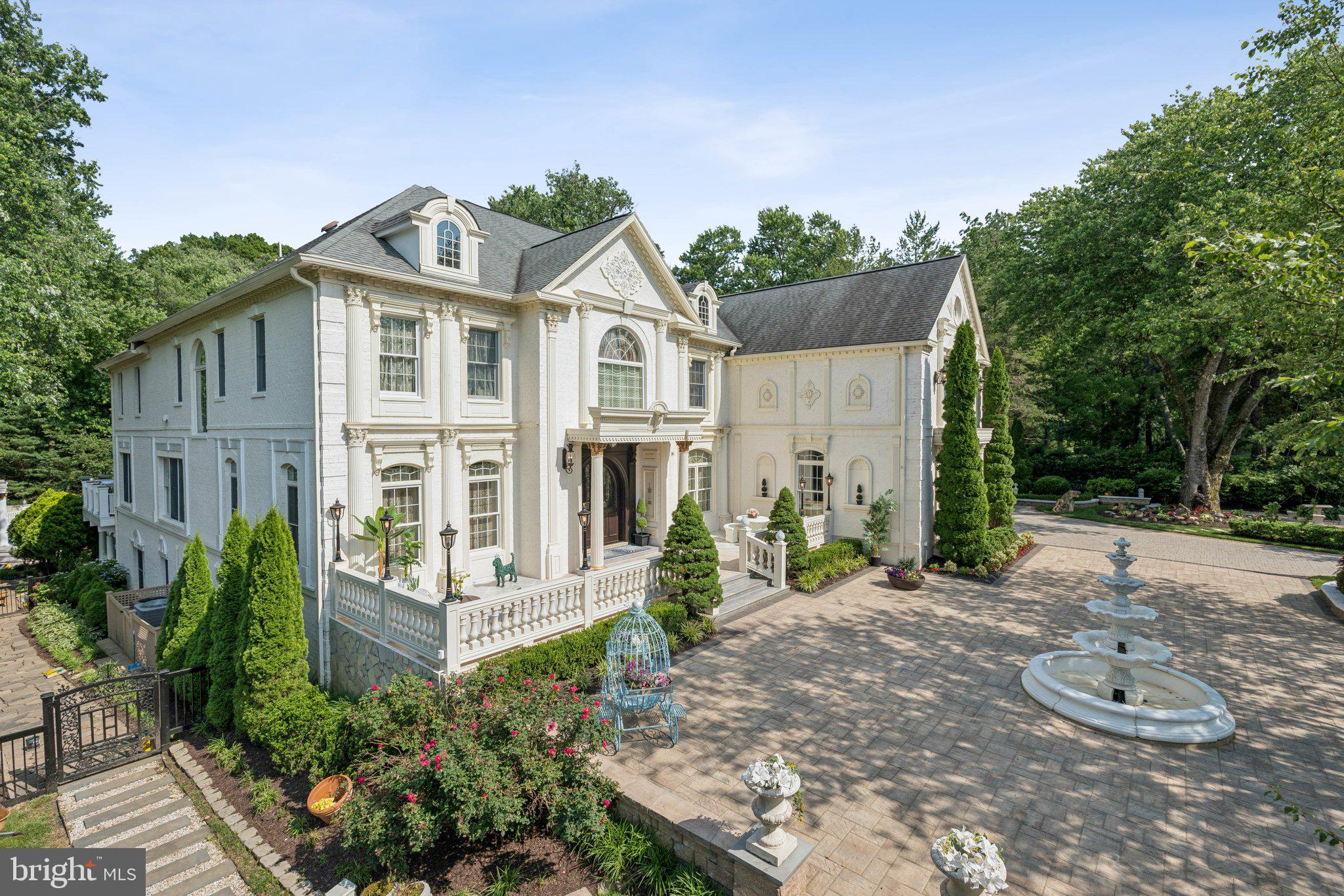 a view of a white house with large windows and plants
