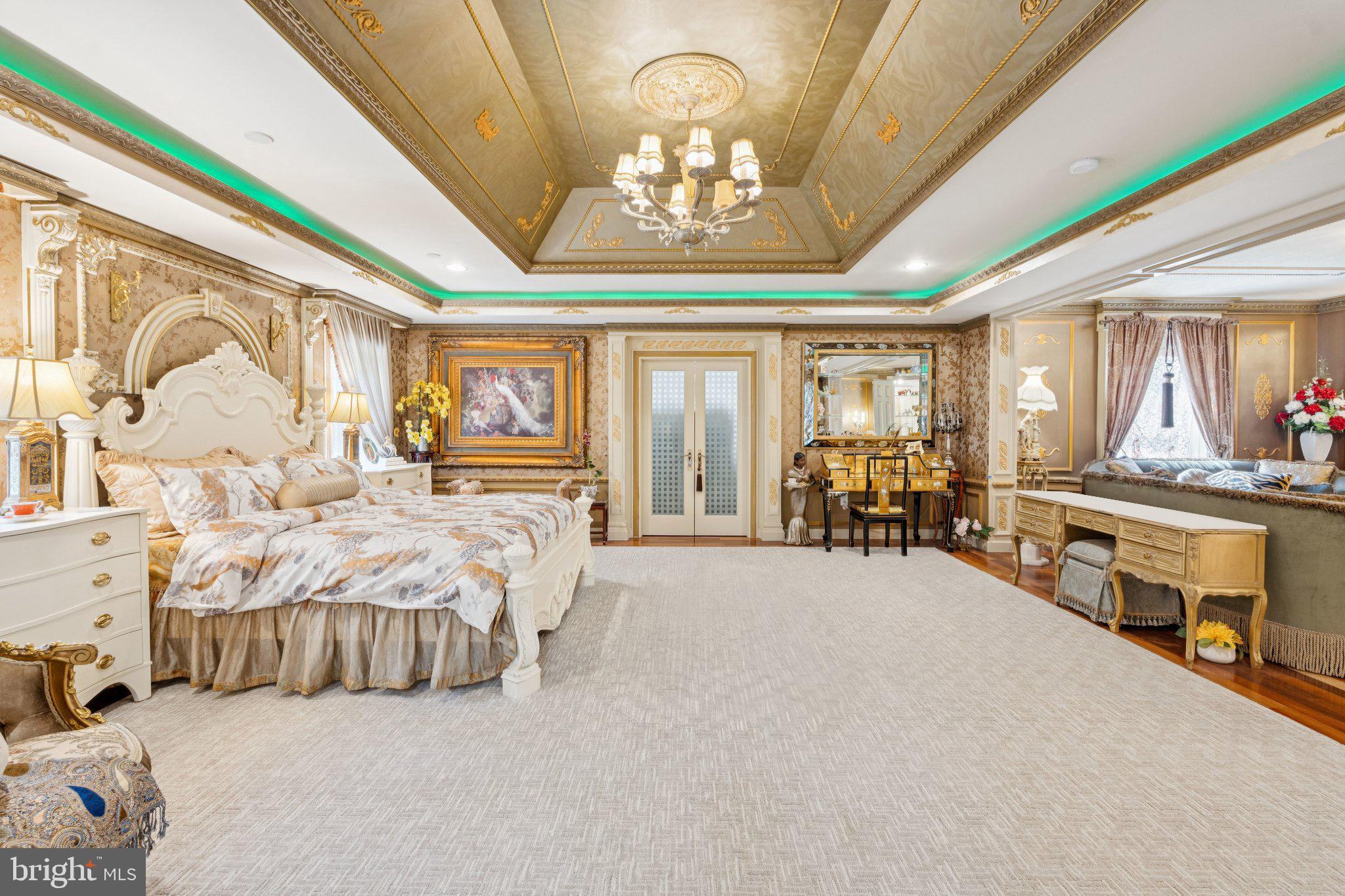 423 Seneca Road Great Falls, VA 22066 - Photo 23 of 52 a spacious bedroom with a bed and a chandelier