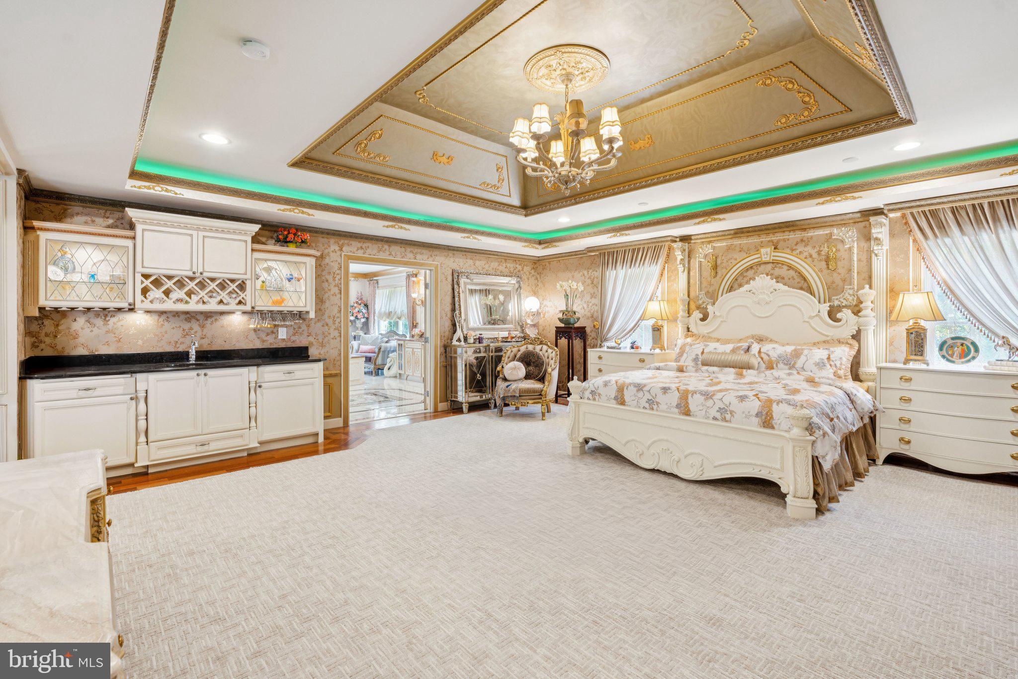 423 Seneca Road Great Falls, VA 22066 - Photo 24 of 52 a spacious bedroom with a large bed and a chandelier