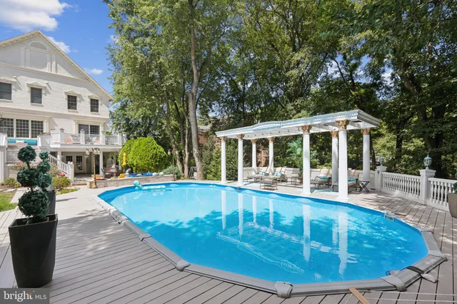 a view of patio with table and chairs potted plants with wooden floor and fence