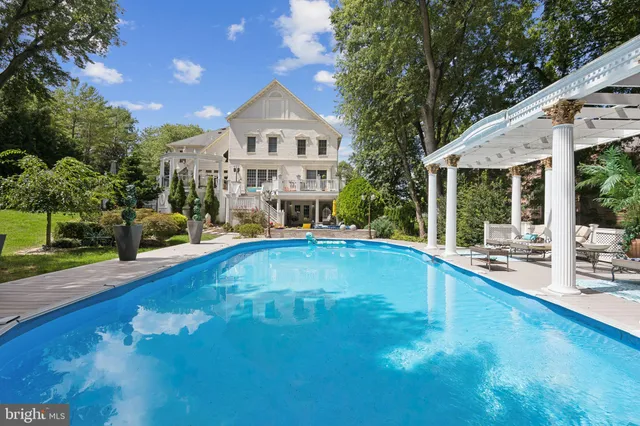 a view of patio with table and chairs potted plants with wooden floor and fence