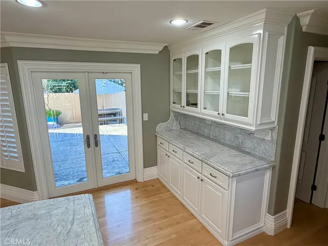an empty room with wooden floor and a kitchen