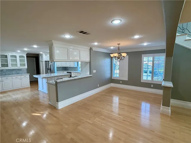 a large kitchen with stainless steel appliances granite countertop a large counter top a sink and a refrigerator