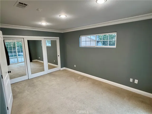 an empty room with sliding door and windows