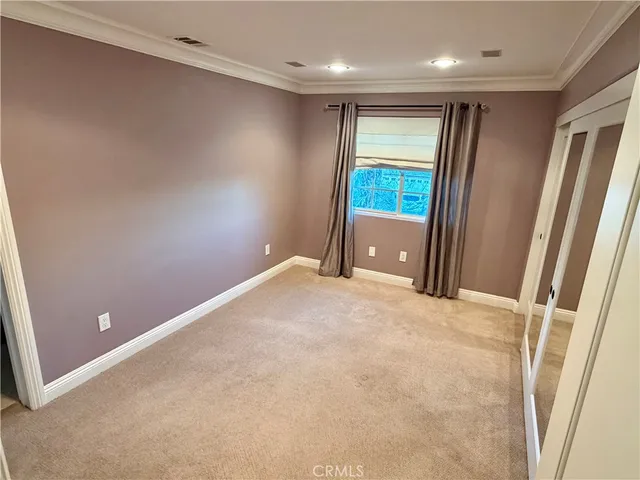 an empty room with closet and windows