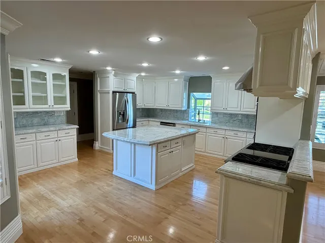 a large kitchen with kitchen island a sink stainless steel appliances and cabinets