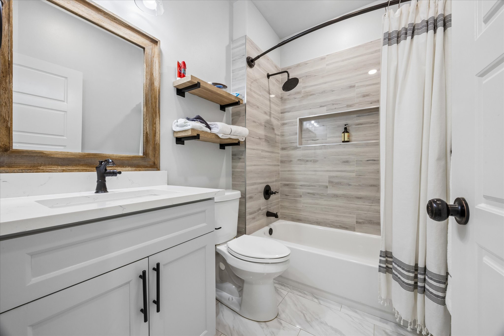 116 Mallard Road Bastrop, TX 78602 - Photo 18 of 31 A modern vanity with stone counters complements the beautifully tiled tub and shower combination.