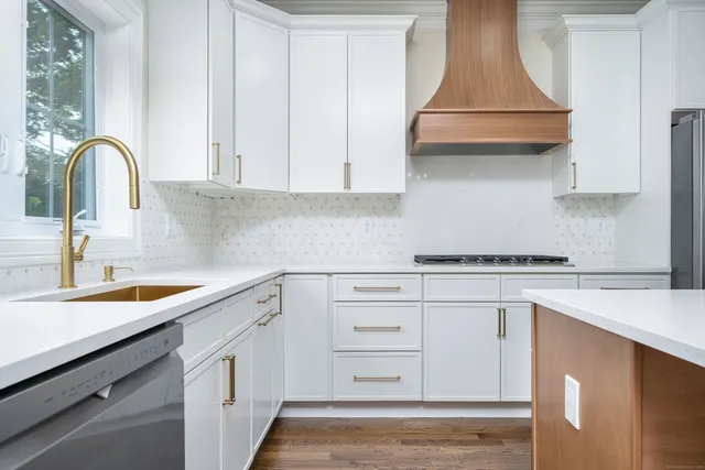 a kitchen with white cabinets appliances and a sink