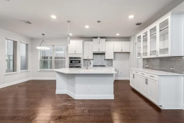 a large kitchen with kitchen island a sink a center island stainless steel appliances and a cabinets