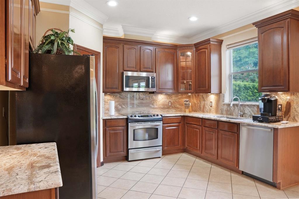 124 Spring Glen Drive DeBary, FL 32713 - Photo 12 of 40 a kitchen with stainless steel appliances granite countertop a refrigerator sink and stove