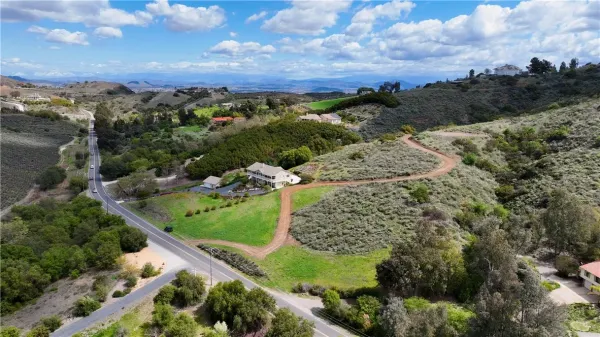 an aerial view of a houses with a yard and lake view