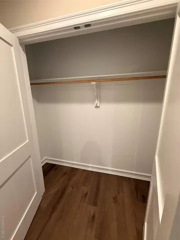 a view of a closet with wooden floor