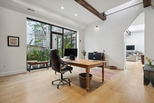 a view of a livingroom with workspace and a window