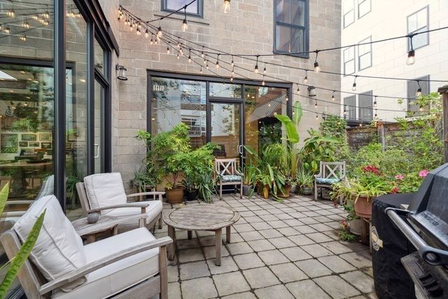 a backyard of a house with barbeque oven table and chairs