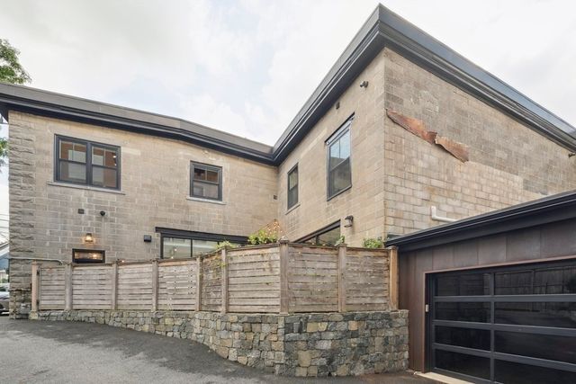a view of a house with a small yard and wooden floor and fence