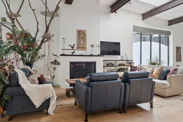 a living room with furniture a flat screen tv and a fireplace