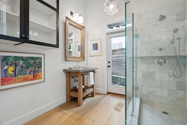 a bathroom with a tub shower sink and mirror