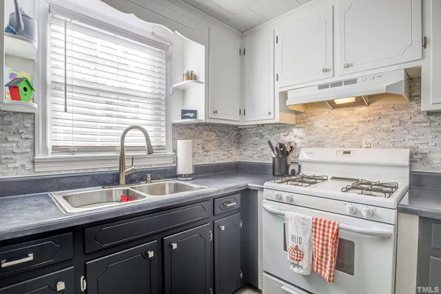 a kitchen with stainless steel appliances granite countertop a sink stove and cabinets