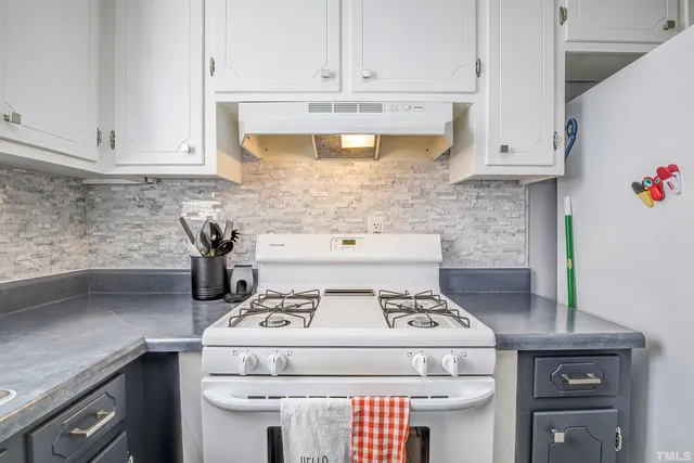 a stove top oven sitting inside of a kitchen
