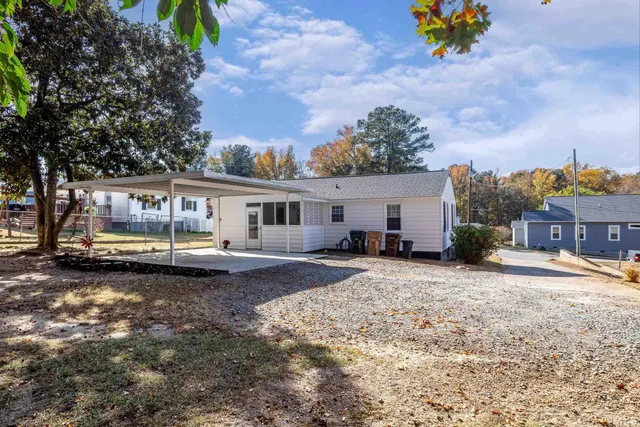 a white house covered with tall trees