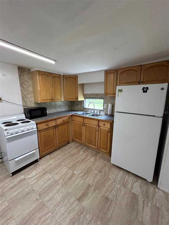 3414 Dr Love Road, Unit C Orlando, FL 32810 - Photo 4 of 9 a kitchen with a sink a stove a refrigerator and a window