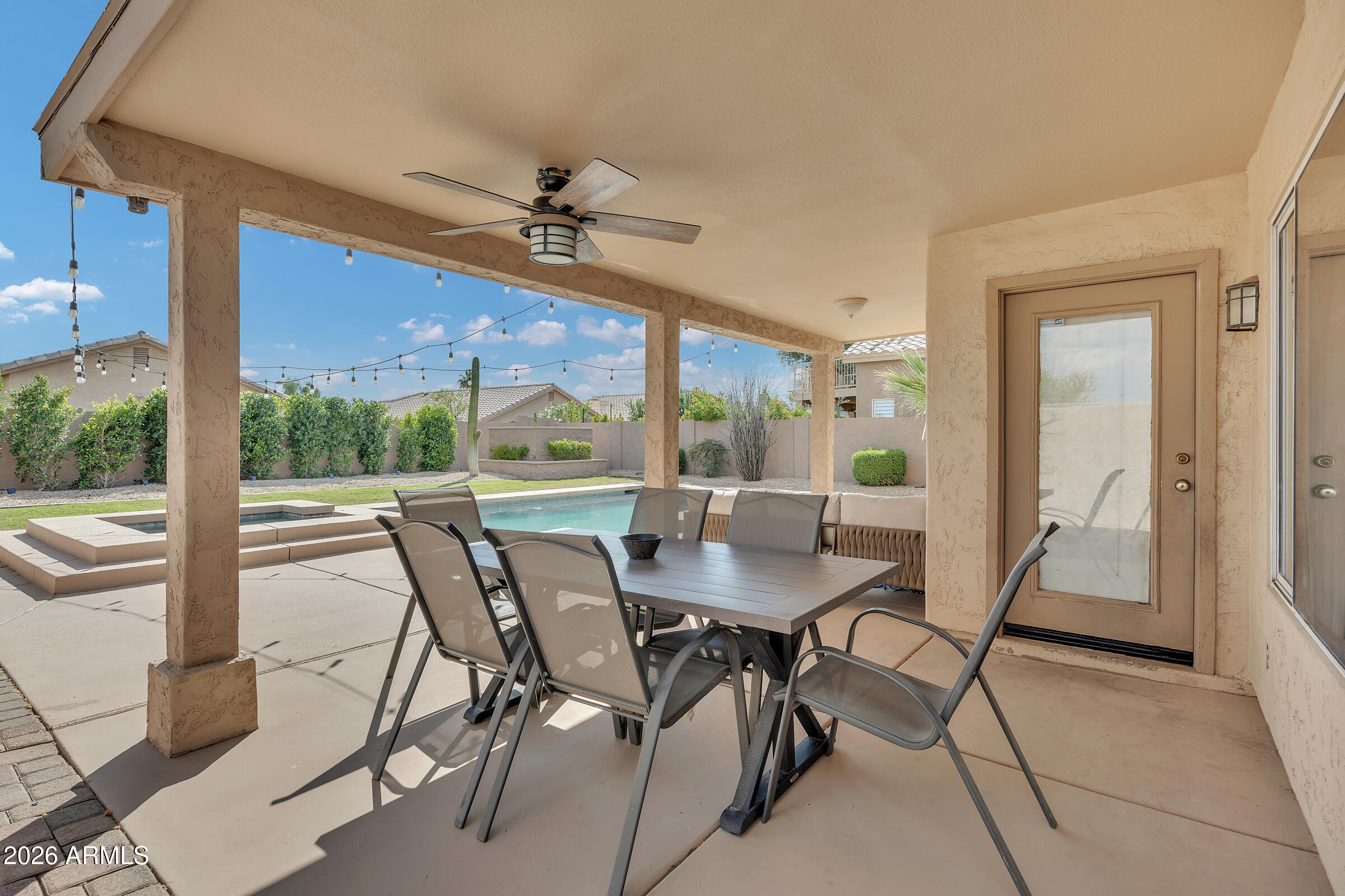 4629 East Gold Poppy Way Phoenix, AZ 85044 - Photo 32 of 46 a dining room with furniture a chandelier and a floor to ceiling window