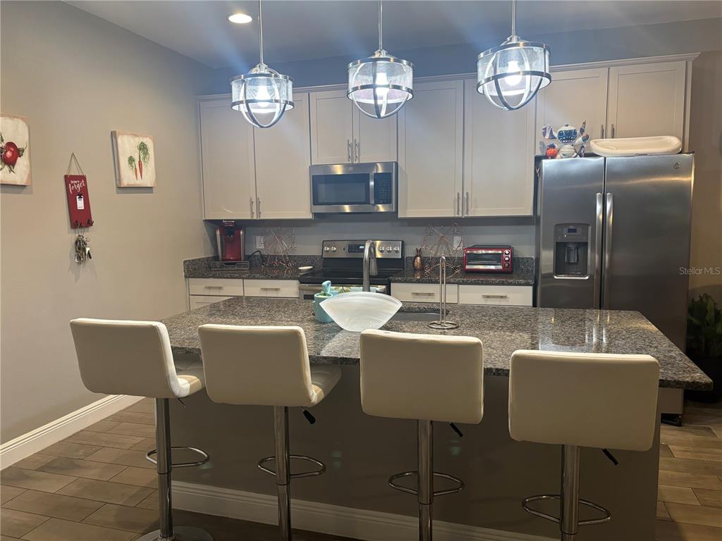 1222 Yorkshire Court Davenport, FL 33896 - Photo 8 of 17 a view of a dining room with furniture a chandelier and wooden floor