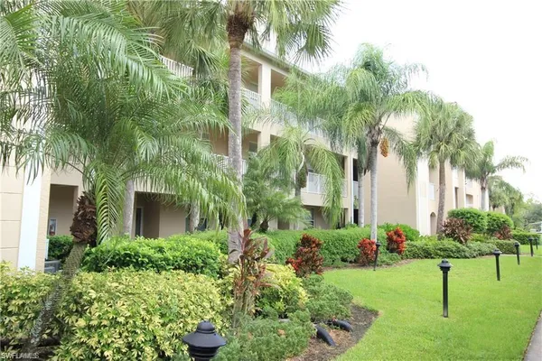 a front view of multi story residential apartment building with yard and green space
