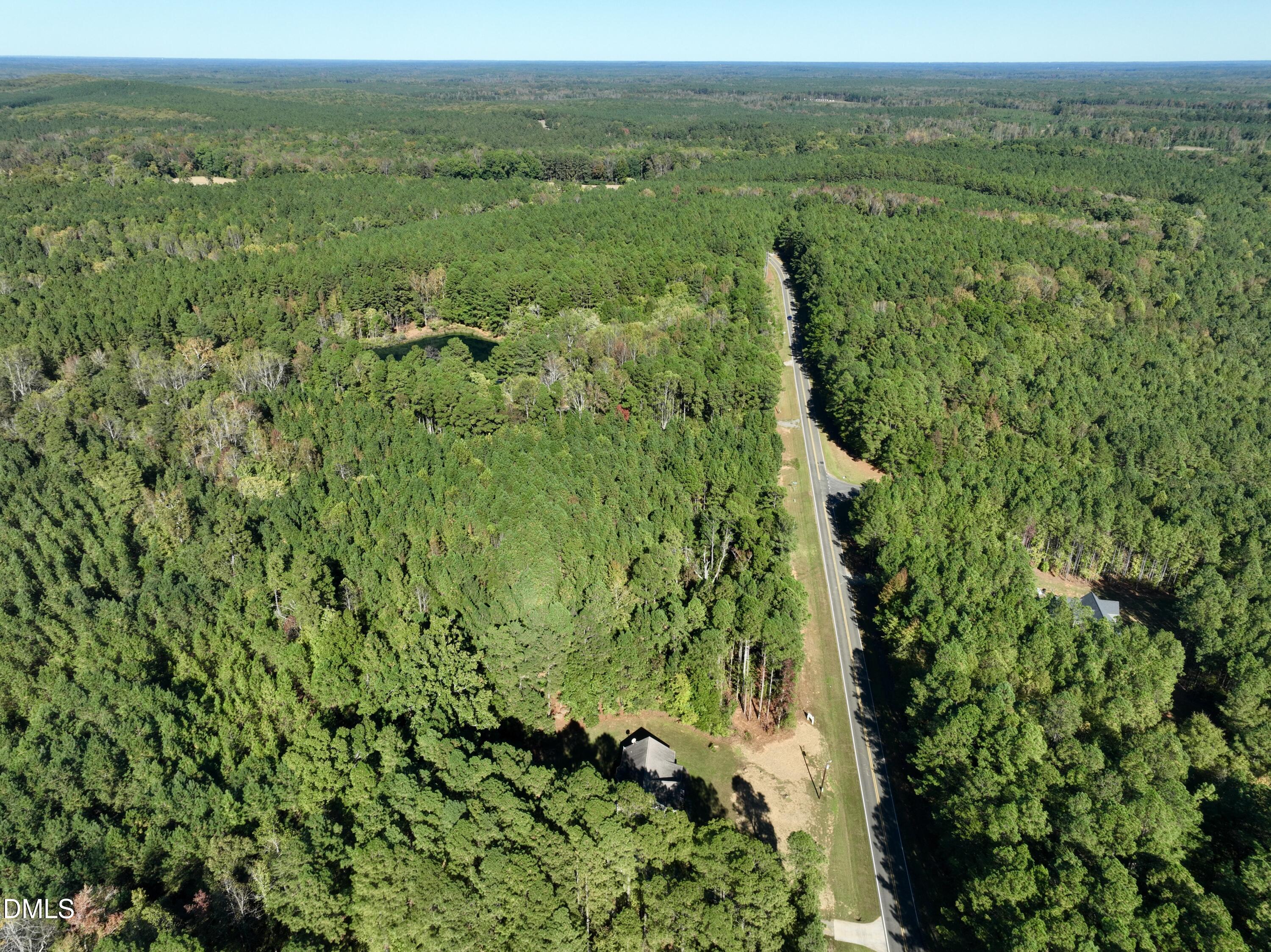2097 Satterwhite Road Oxford, NC 27565 - Photo 37 of 40 a view of a lush green forest with trees and some houses