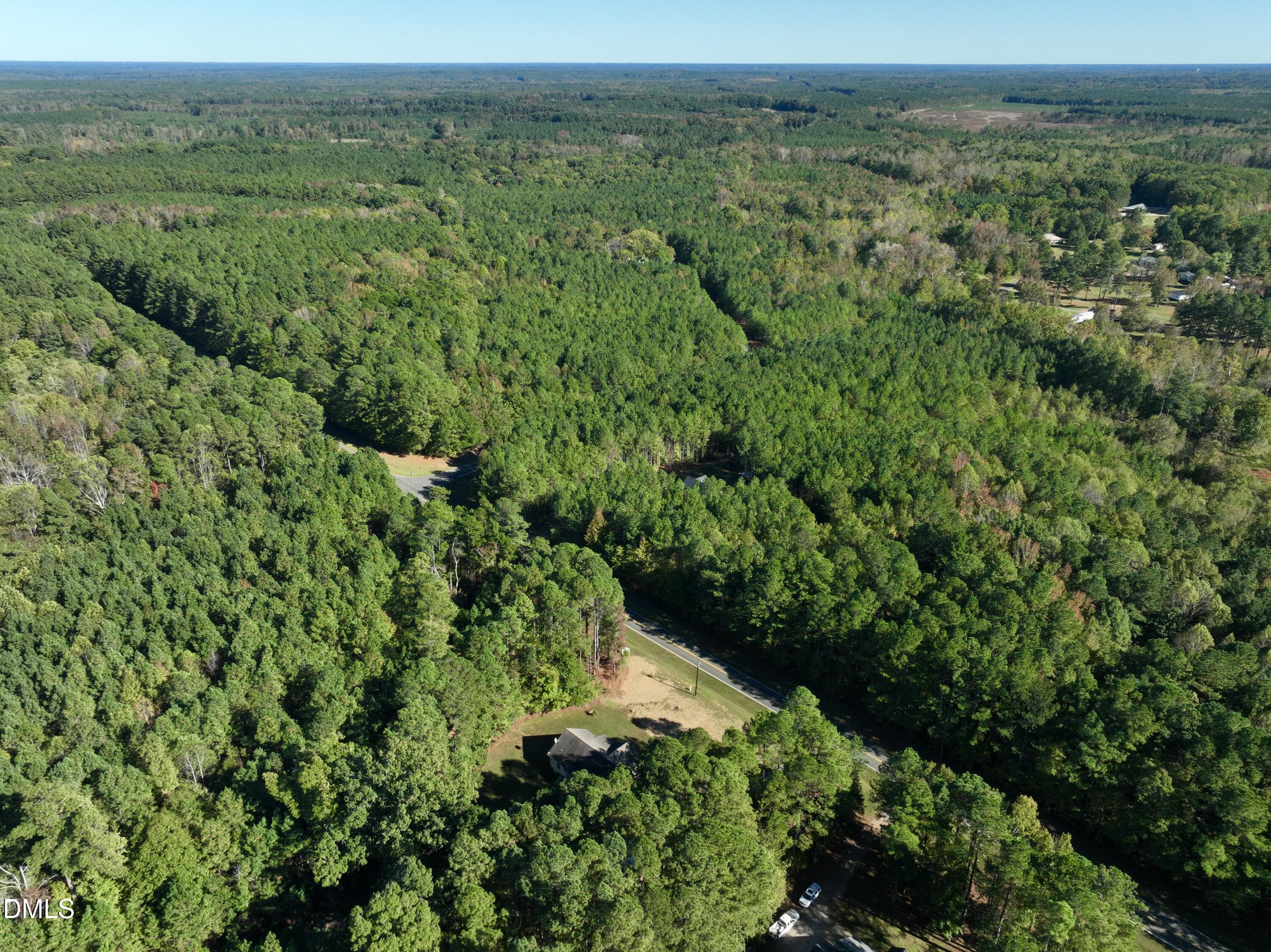 2097 Satterwhite Road Oxford, NC 27565 - Photo 38 of 40 a view of a lush green forest with trees and some houses