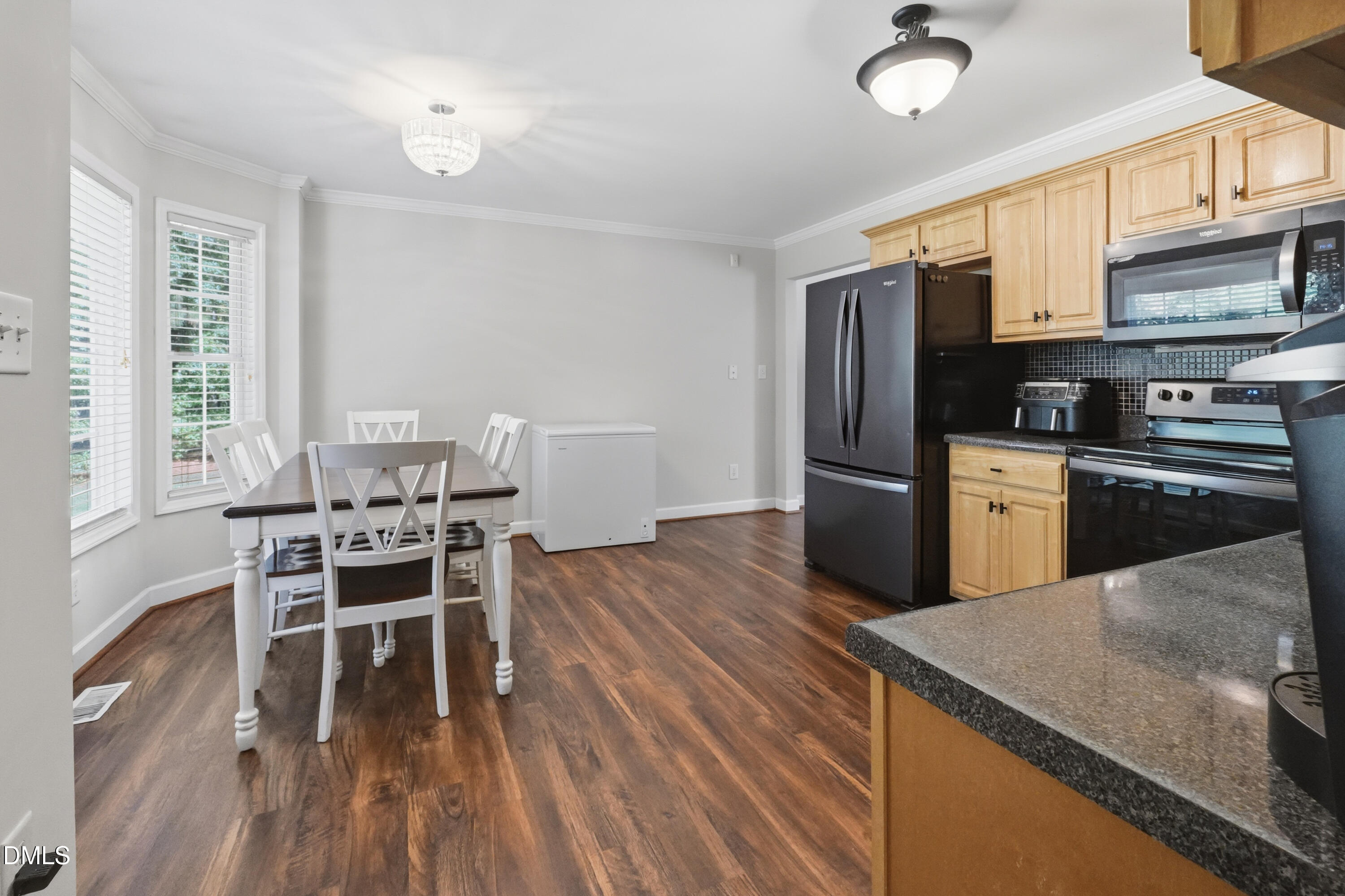 2097 Satterwhite Road Oxford, NC 27565 - Photo 7 of 40 a kitchen with stainless steel appliances granite countertop a stove top oven a sink dishwasher a dining table and chairs with wooden floor