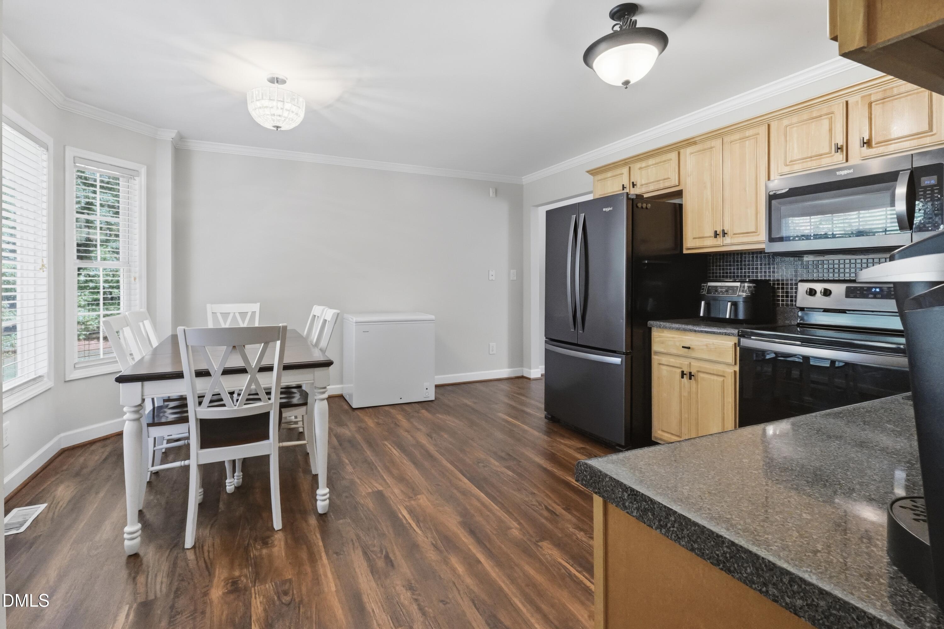 2097 Satterwhite Road Oxford, NC 27565 - Photo 8 of 40 a kitchen with granite countertop a stove top oven a sink dishwasher a dining table and chairs with wooden floor